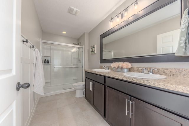 bathroom featuring tile patterned flooring, vanity, toilet, and walk in shower