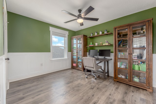 office featuring ceiling fan, light hardwood / wood-style floors, and a textured ceiling