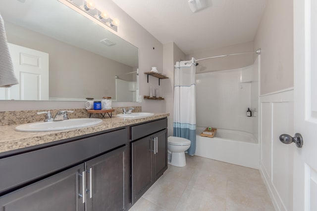 full bathroom with tile patterned floors, vanity, toilet, and shower / bath combo with shower curtain