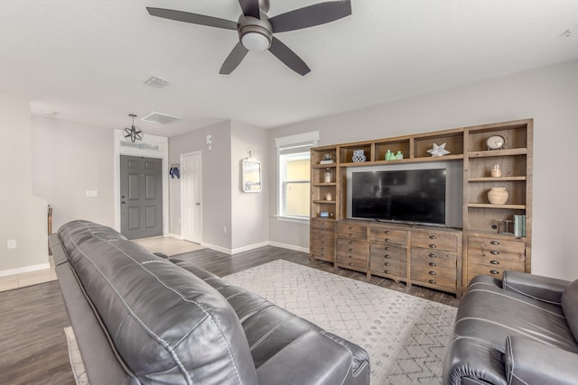 living room featuring ceiling fan and dark wood-type flooring