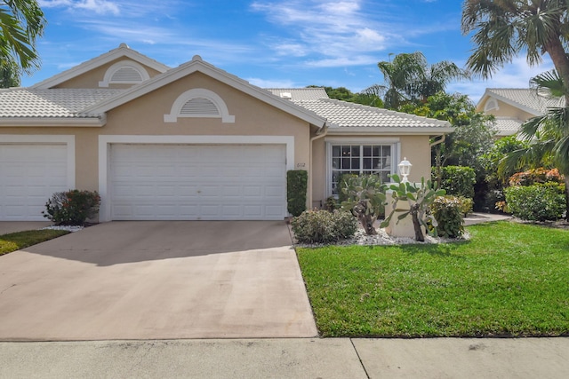 6112 Greenspointe Dr Unit 53, Boynton Beach, FL 33437 - view of front of home with stucco siding, a front lawn, driveway, and an attached garage