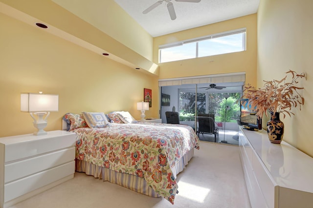 carpeted bedroom featuring a ceiling fan, access to outside, and a high ceiling