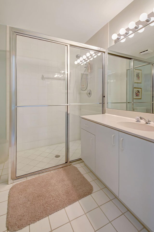 bathroom with a stall shower, vanity, and tile patterned floors