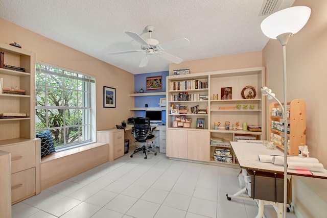 home office featuring a textured ceiling, ceiling fan, light tile patterned floors, and visible vents