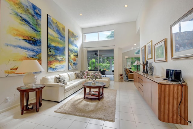 living room with light tile patterned floors, baseboards, a ceiling fan, a towering ceiling, and recessed lighting