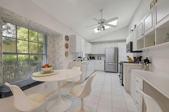 kitchen with open shelves, stainless steel appliances, lofted ceiling, light tile patterned floors, and light countertops