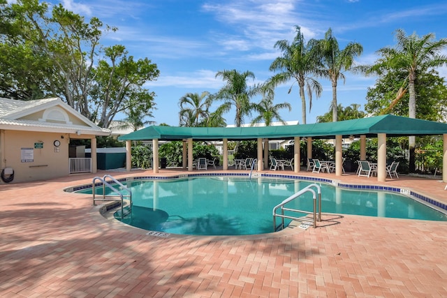 pool with a patio area and fence