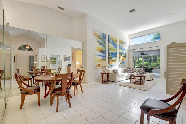 living room with ceiling fan, light tile patterned floors, and lofted ceiling