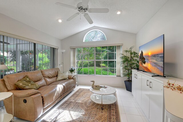 tiled living room featuring a textured ceiling, ceiling fan, and lofted ceiling