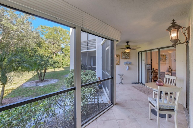 unfurnished sunroom featuring ceiling fan