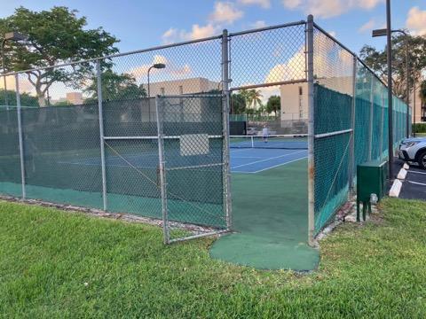 view of sport court featuring a lawn