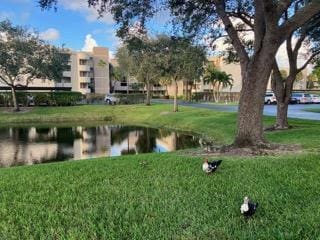 surrounding community with a yard and a water view