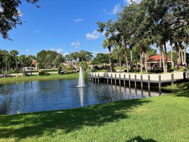 view of dock featuring a lawn and a water view