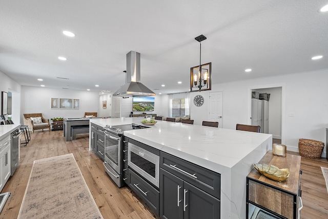 kitchen with a center island, stainless steel appliances, island exhaust hood, pendant lighting, and light wood-type flooring