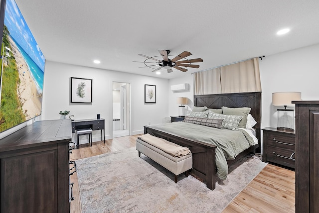 bedroom featuring an AC wall unit, ceiling fan, and light hardwood / wood-style floors