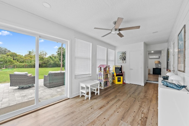 game room with hardwood / wood-style floors, a textured ceiling, and ceiling fan