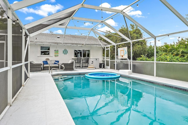 view of pool with glass enclosure and a patio