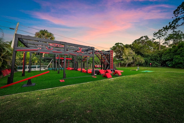 playground at dusk featuring a lawn