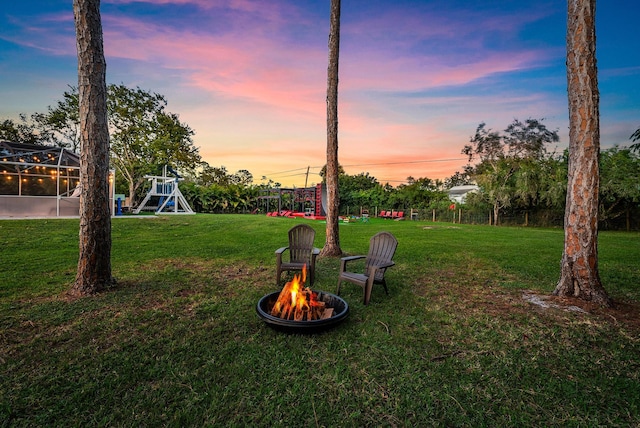 yard at dusk featuring a fire pit