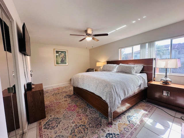 bedroom with ceiling fan and light tile patterned flooring