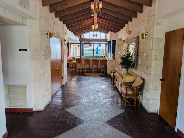 hall with beamed ceiling and high vaulted ceiling