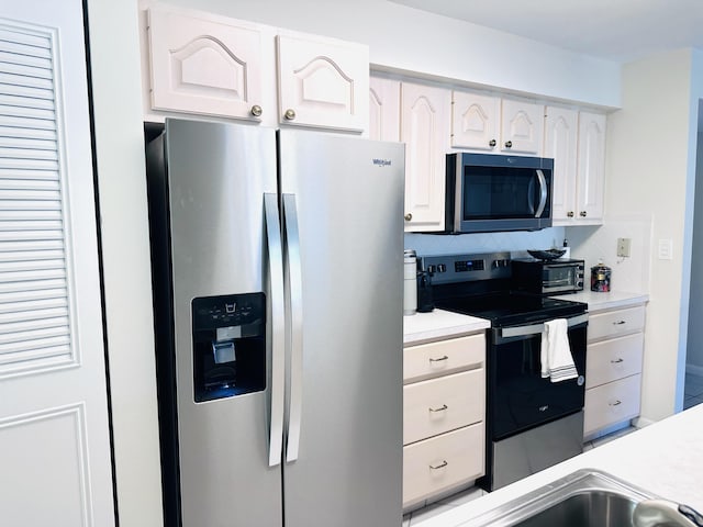 kitchen featuring backsplash, white cabinets, and stainless steel appliances