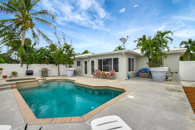 view of swimming pool featuring grilling area, an in ground hot tub, and a patio