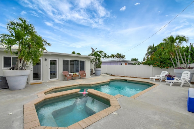 view of swimming pool featuring a patio area and an in ground hot tub