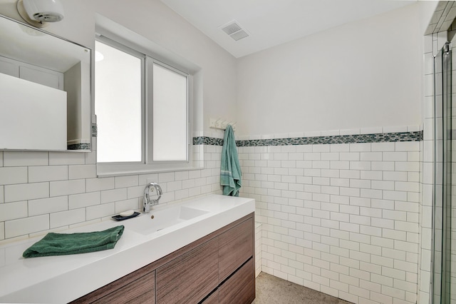 bathroom featuring vanity and tile walls