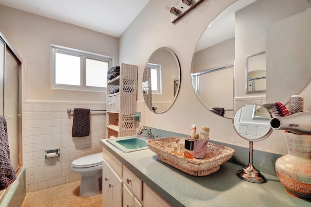 bathroom featuring plenty of natural light, toilet, tile walls, and vanity