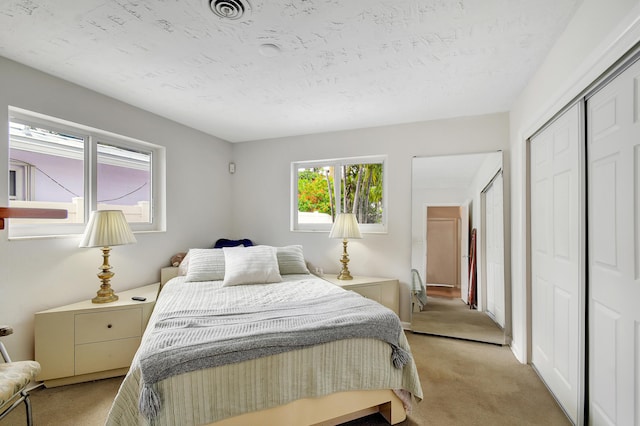 bedroom with a closet and light carpet