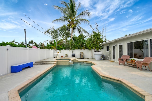 view of swimming pool with an in ground hot tub, a patio, and central air condition unit