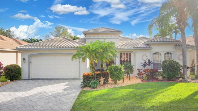 mediterranean / spanish-style home featuring a garage and a front yard