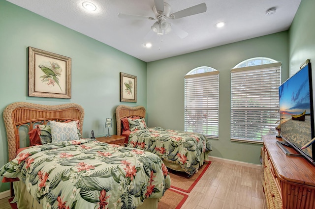 bedroom featuring multiple windows, light hardwood / wood-style flooring, and ceiling fan