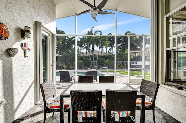 sunroom / solarium featuring ceiling fan, lofted ceiling, and a wealth of natural light