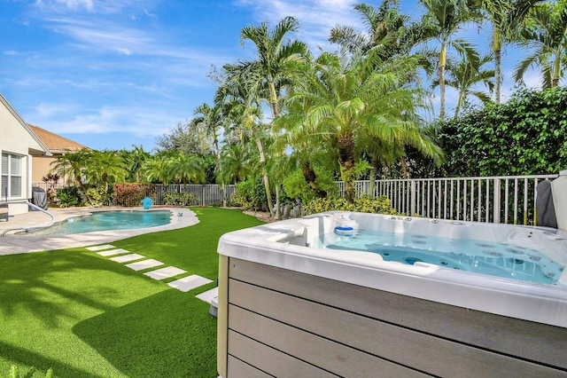 view of pool featuring a lawn and a hot tub