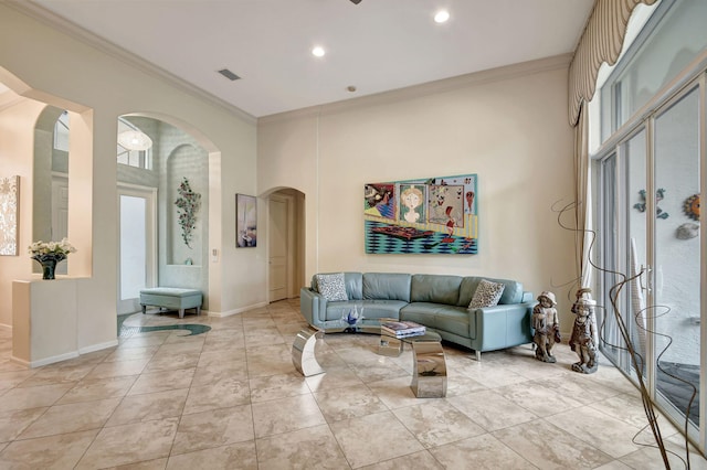 living room featuring a high ceiling, crown molding, and light tile patterned flooring