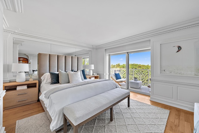 bedroom featuring access to exterior, light hardwood / wood-style floors, and ornamental molding