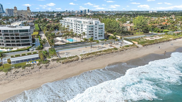 birds eye view of property with a water view and a beach view