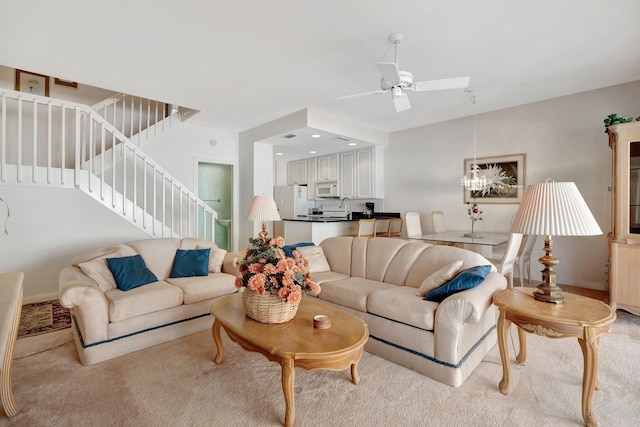 living room featuring ceiling fan, light colored carpet, and sink