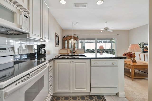 kitchen featuring ceiling fan, kitchen peninsula, white appliances, light carpet, and white cabinets