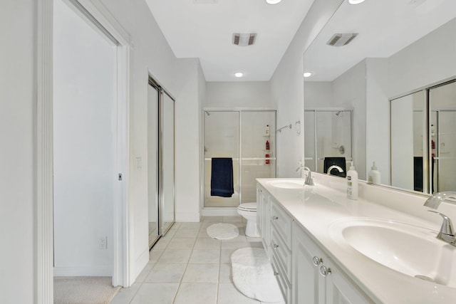 bathroom featuring tile patterned floors, a shower with door, vanity, and toilet