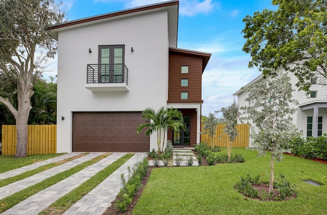 view of front of home with a balcony, a front lawn, and a garage