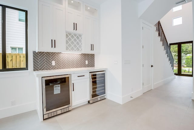 bar featuring tasteful backsplash, wine cooler, and white cabinets