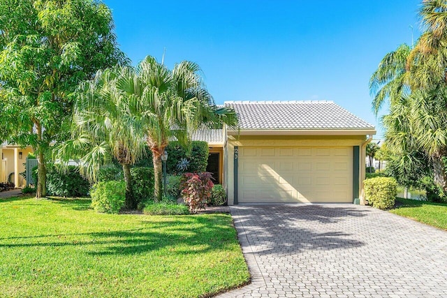 view of front of home with a front yard and a garage