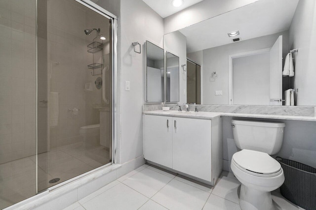 bathroom with tile patterned flooring, vanity, toilet, and a shower with door