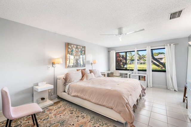 bedroom with light tile patterned floors, a textured ceiling, and ceiling fan