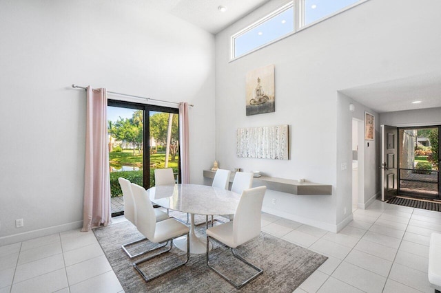 tiled dining room with a healthy amount of sunlight and a towering ceiling