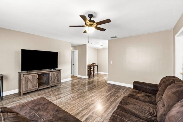 living room featuring hardwood / wood-style floors and ceiling fan