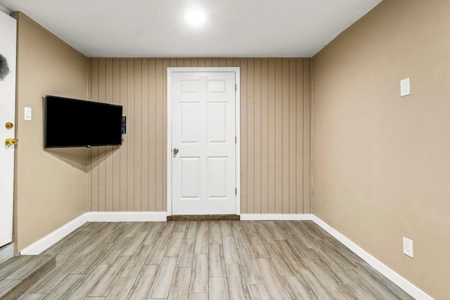 spare room with hardwood / wood-style flooring and wooden walls